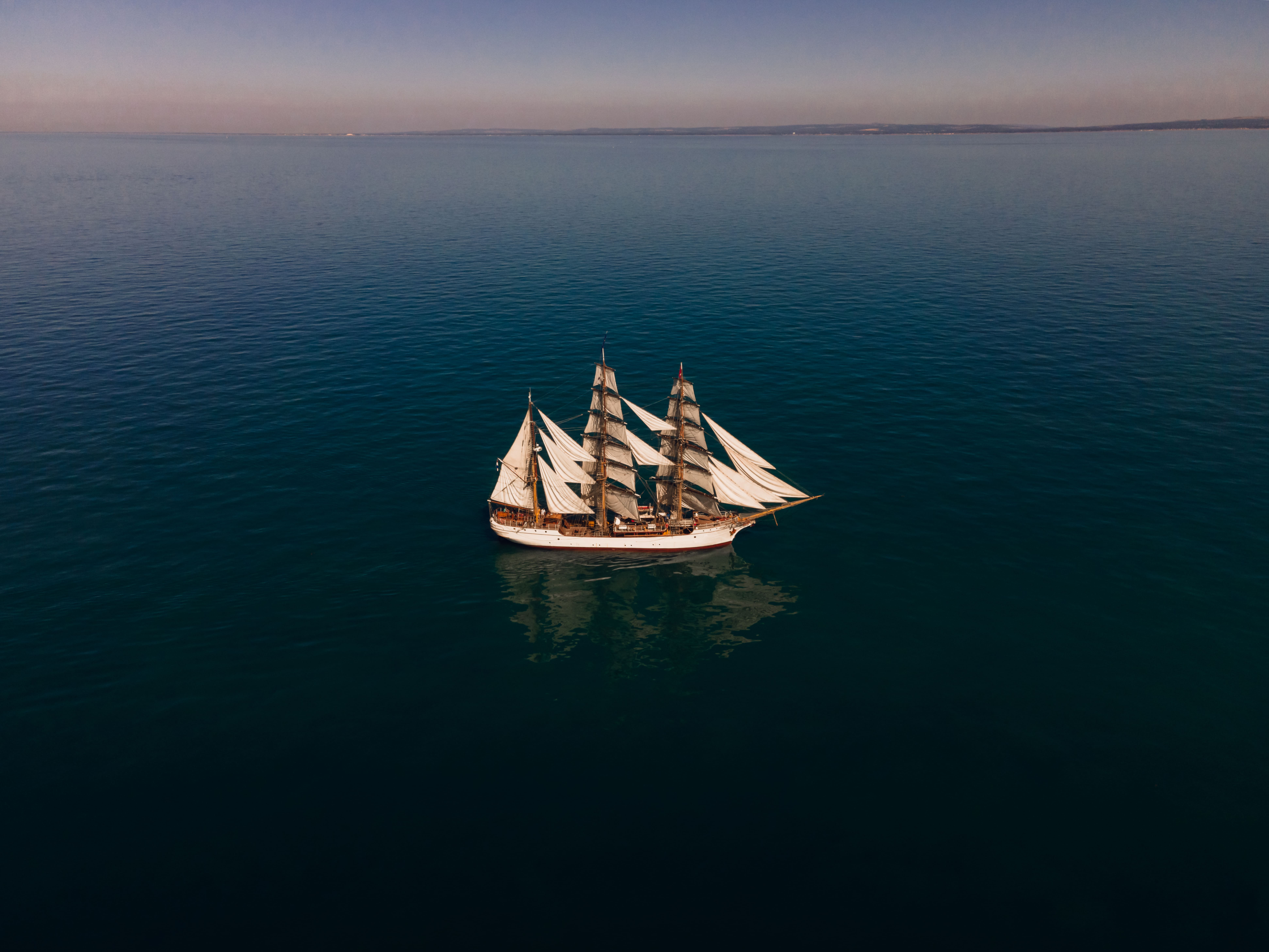 Bark EUROPA aerial view at dusk on a glassy Pacific Ocean